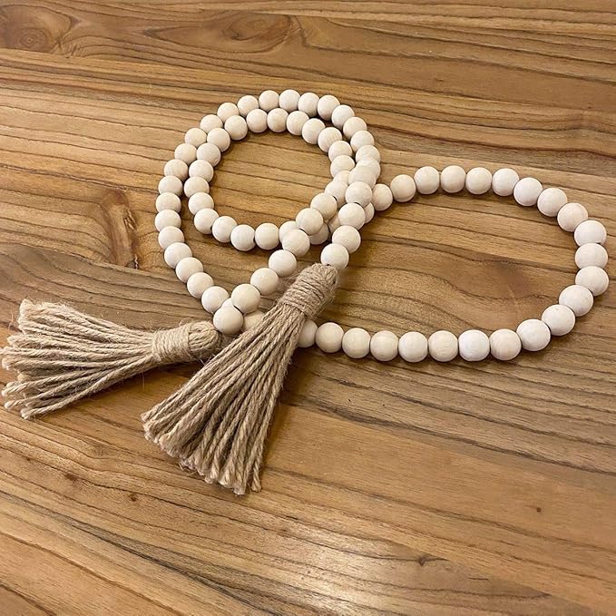 A string of light beige wooden beads with beige tassels.