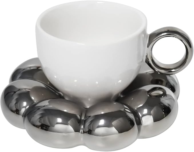 White ceramic mug with a ring handle, sits on a silver flower shaped coaster. "Koythin High Quality Porcelain" appears on the tag.