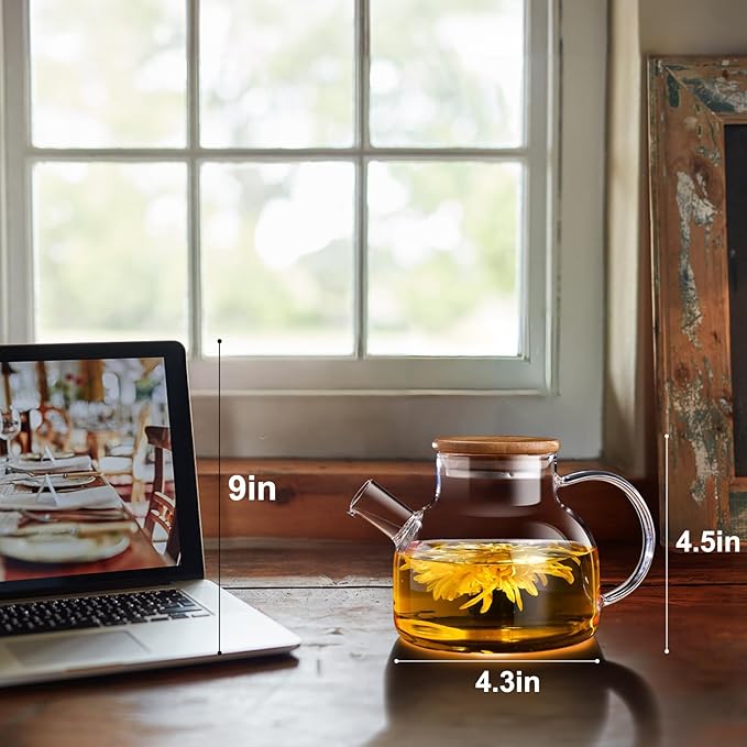 A glass teapot with a wooden lid is displayed beside its box. The box reads, "Glass Teapot 20 oz/600ml", showcasing a flower tea being prepared. The teapot also contains flower tea, creating a visually appealing presentation.